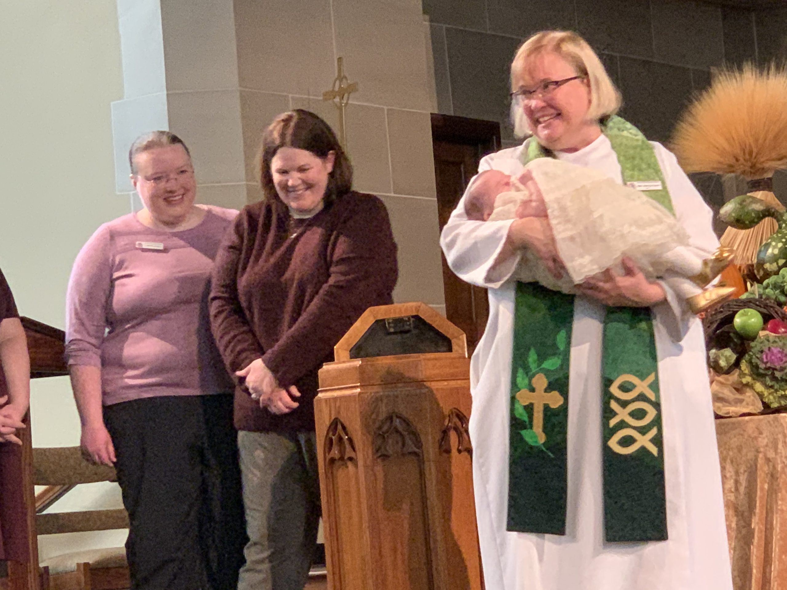 Pastor Nancy holding baby being baptized